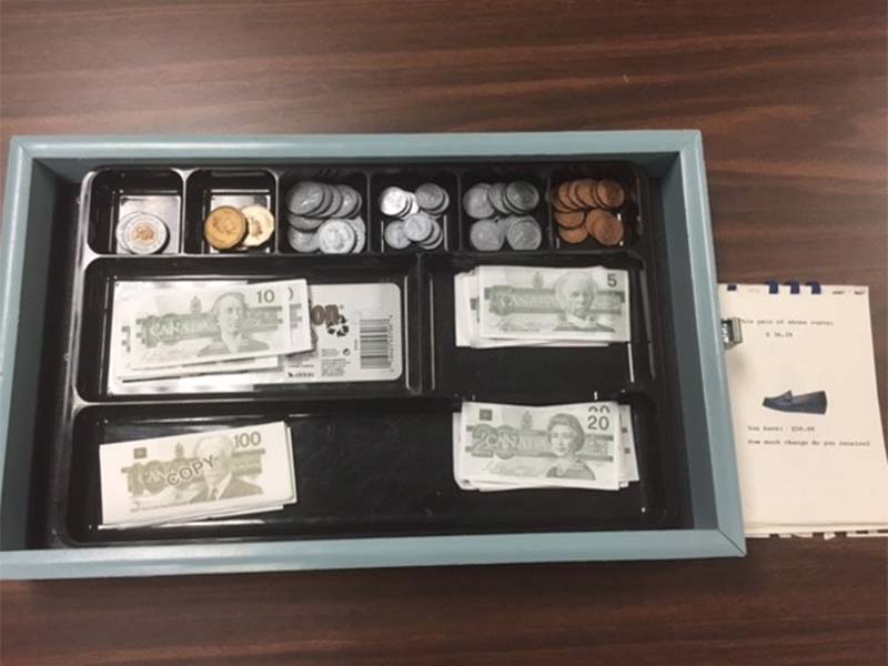 Tool used in the vocational assessment program to evaluate an individual's money handling abilities and skills. The tool consists of a cash drawer with coins and paper money.